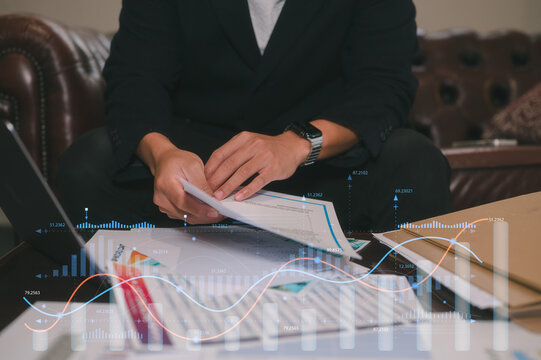 Man sitting in office or library analyse report data, using laptop for work or study data analysis in business or research on data charts