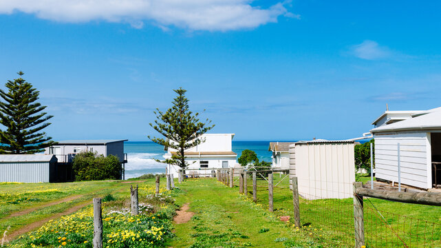 Humble beach shack by the sea, with vacant land behind