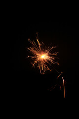 Yellow sparks fly on a black background, layered with grain, noise, and glowing effects to give a...