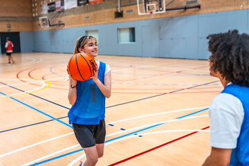 Young female basketball player passing the ball during training