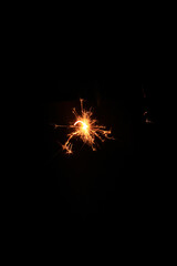 Fototapeta premium Yellow sparks fly on a black background, layered with grain, noise, and glowing effects to give a gritty, cinematic feel full of motion, contrast, and intense visual energy.