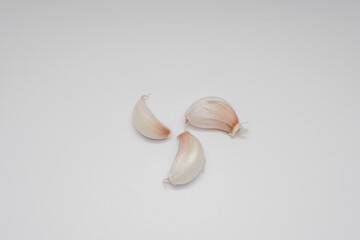 Photographic still life of fresh garlic cloves on a white background for culinary or food blog use minimalist style