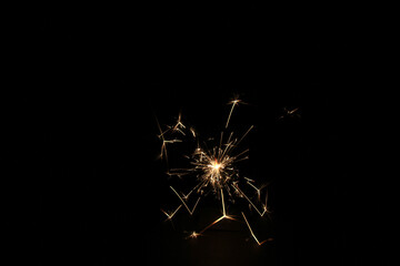 Yellow sparks fly on a black background, layered with grain, noise, and glowing effects to give a...