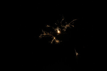 Yellow sparks fly on a black background, layered with grain, noise, and glowing effects to give a...