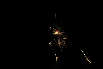 Yellow sparks fly on a black background, layered with grain, noise, and glowing effects to give a...