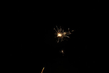 Yellow sparks fly on a black background, layered with grain, noise, and glowing effects to give a...