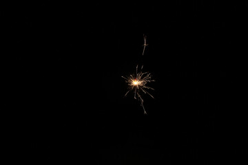Yellow sparks fly on a black background, layered with grain, noise, and glowing effects to give a...