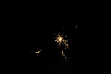 Yellow sparks fly on a black background, layered with grain, noise, and glowing effects to give a...