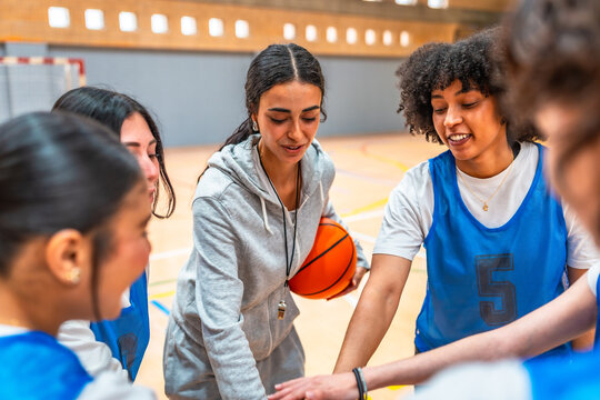 Female basketball coach motivating her team during time out