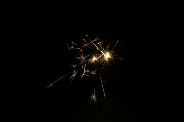 Yellow sparks fly on a black background, layered with grain, noise, and glowing effects to give a...