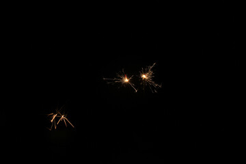 Yellow sparks fly on a black background, layered with grain, noise, and glowing effects to give a...