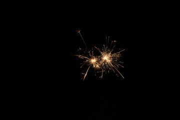 Yellow sparks fly on a black background, layered with grain, noise, and glowing effects to give a...