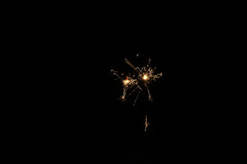 Yellow sparks fly on a black background, layered with grain, noise, and glowing effects to give a...