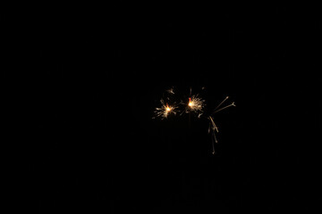 Yellow sparks fly on a black background, layered with grain, noise, and glowing effects to give a...