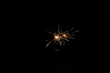 Yellow sparks fly on a black background, layered with grain, noise, and glowing effects to give a...
