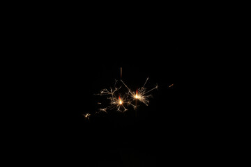 Yellow sparks fly on a black background, layered with grain, noise, and glowing effects to give a...