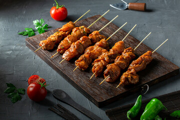 Chicken thigh shish tawook on wooden board, ready for grilling.