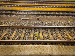 Steel railway tracks and ballast on a quiet morning at the Diepholz train station platform with...