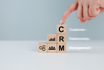 Three wooden cubes with letters (crm) customer relationship management technology and data...