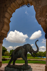 Obraz premium Bronze elephant statue framed by ornate archway.