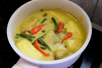 Indonesian homemade food, tuna yellow curry with long beans and tofu.