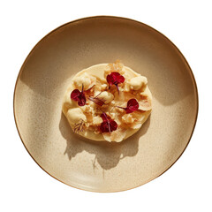 Creamy dessert garnished with red petals and crunchy topping