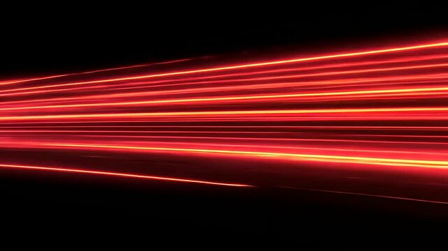 Abstract red light streaks create a dynamic visual effect against a black background, ideal for design