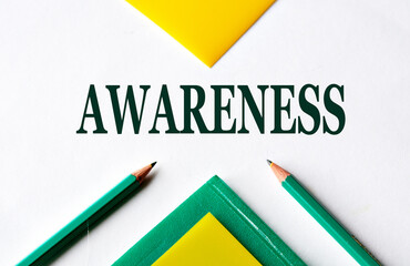 AWARENESS - word close-up on white sheet with folders and pencils