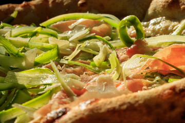 Green asparagus cut into thin strips lying on pizza, macro close-up, asparagus dish.