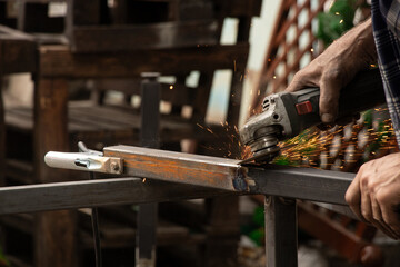 Grinding a weld on metal structures with a grinder, work of a master on processing joints after welding