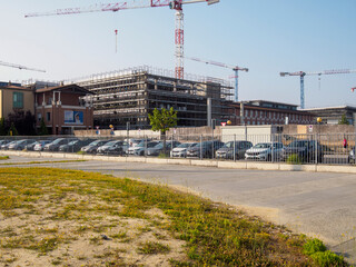 hospital structure and situation of a construction site with cranes and park in a rural landscape of europe for photo stock agency