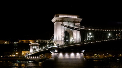 Chain Bridge in Budapest illuminated at night over the Danube River.