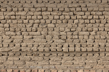 Weathered adobe brick wall texture in rustic outdoor setting