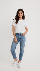 Full length of confident Greek woman smiling in a casual outfit in a white tshirt and jeans standing with her arm and leg crossed on plain white background