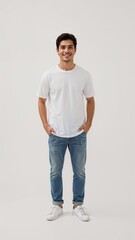 Full length of confident Indonesian man smiling in a casual outfit in a white tshirt and jeans standing with his arm and leg crossed on plain white background