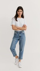 Full length of confident Malaysian teenage girl smiling in a casual outfit in a white tshirt and jeans standing with her arm and leg crossed on plain white background