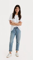 Full length of confident Pakistani teenage girl smiling in a casual outfit in a white tshirt and jeans standing with her arm and leg crossed on plain white background