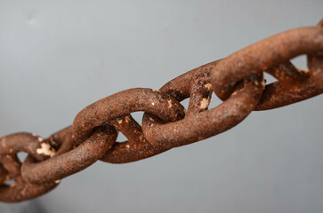 The rusty chain of the anchor on board of platform supply vessel. The chain is attached to a windlass from one and, and to the anchor - from another. Rust does not affect the chain capacity to hold