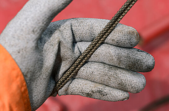 The hand in glove is keeping a rope. Safety gloves are mandatory for the seafarers working on board, as it protects the hand from injury 