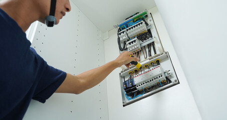 Electrician working checking a switchboard with fuses