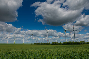 Modern wind turbines spinning over vibrant green fields in rural Germany. A powerful symbol of the Energiewende and Germany’s response to climate change and energy transition. green energy