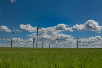 Modern wind turbines spinning over vibrant green fields in rural Germany. A powerful symbol of the Energiewende and Germany’s response to climate change and energy transition. green energy