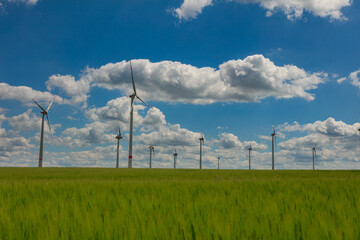 Modern wind turbines spinning over vibrant green fields in rural Germany. A powerful symbol of the Energiewende and Germany’s response to climate change and energy transition. green energy
