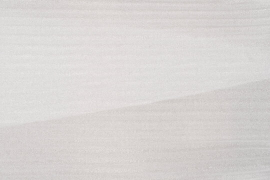 A close-up of the texture of a light grey EPE foam sheet with a subtle diagonal gradient and horizontal striations