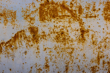 Weathered white metal surface with rust and corrosion in industrial setting
