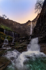 Scenic long exposure of the Salto del Nervión waterfall at sunset, located in a rocky canyon between Burgos and the Basque Country, Spain