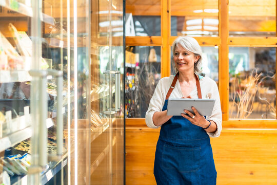 Supermarket employee using digital tablet checking stock availability