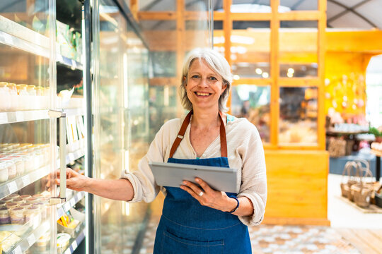 Supermarket employee doing inventory using digital tablet