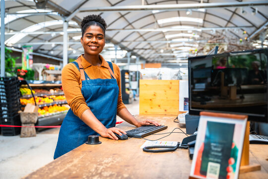 Supermarket cashier working at cash register in grocery store