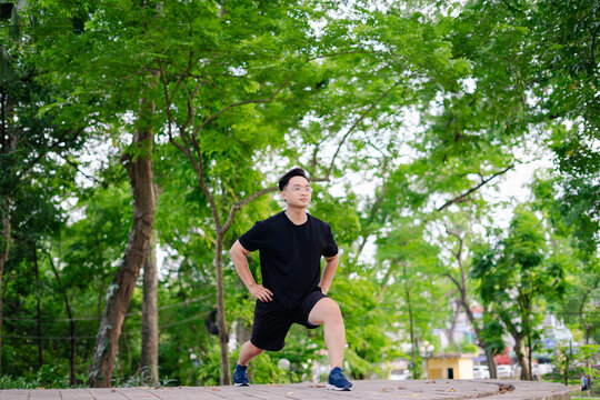 Man performs lunges in a lush green park during a bright day while focusing on fitness and wellness, showcasing dedication to outdoor exercise